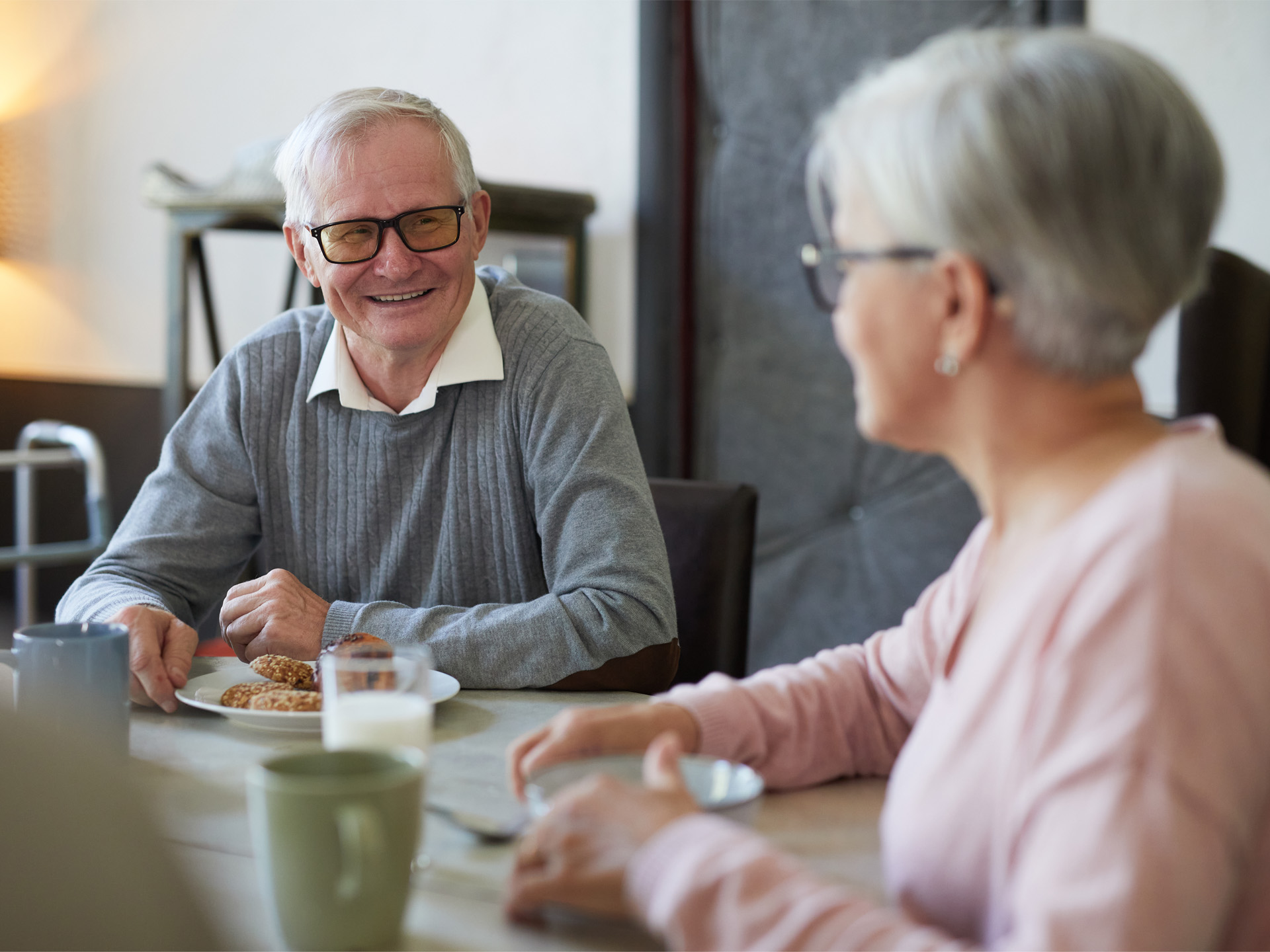 Älterer Mann und Frau sitzen in Cafeteria